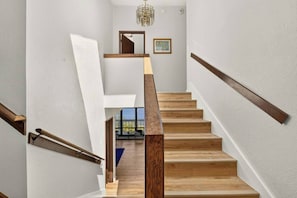 Eine Treppe mit Holzstufen und Metallgeländern, die zu einem Zimmer mit Ausblick führt.