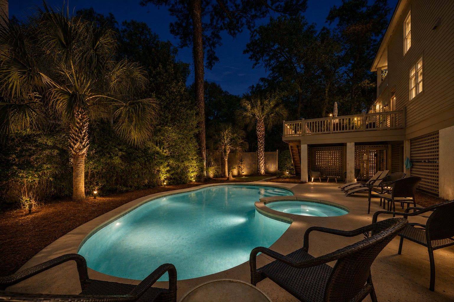 A swimming pool with lounge chairs and a covered patio area.