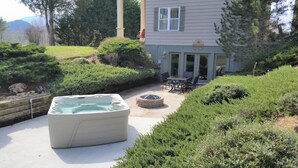 Boblebad i en anlagt baghave med en terrassemiljø og et hus i baggrunden.