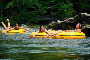 People floating on yellow inflatable tubes in a body of water surrounded by greenery. - Entire Home in Townsend w/HOT TUB and Stunning Mtn Views (Townsend)