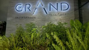 Fachada de edificio con letreros iluminados que indican 'GRAND' y 'By LINARES'.