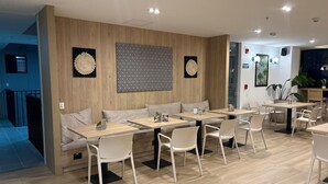 Un restaurante moderno con paredes de madera, sillas blancas y mesas.