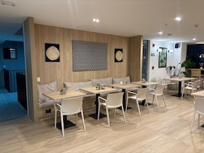 Ein modernes Restaurant mit Holzwänden, weißen Stühlen und Tischen.