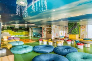 A colorful playroom with bean bags, tables, and a ceiling with hanging lights. - Luxury Oceanfront Studio King Bed / Garza Blanca Cancun / Optional All-Inclusive (Cancun)
