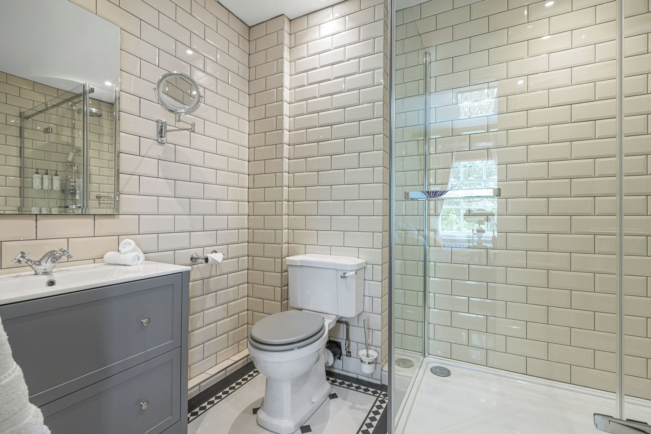 Un baño moderno con inodoro, lavamanos y zona de ducha.