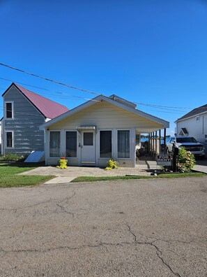 A single-story house with a front porch, a garage, and a driveway. - Peaceful 3-bedroom waterfront house with AC on charming Sodus Bay (Sodus Point)