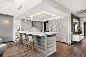 A modern kitchen with a central island, pendant lighting, and a marble backsplash. - Luxury 3BR Villa Royal at Plantation (Dorado)