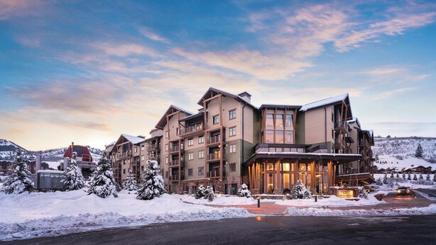 A multi-story hotel with a ski resort backdrop, featuring a prominent entrance and multiple balconies. - Spring break Ski trip at Park City!! (Park City)