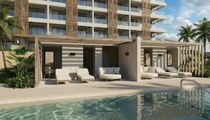 Un hotel con zona de piscina, múltiples sillones de descanso y un edificio con balcones.