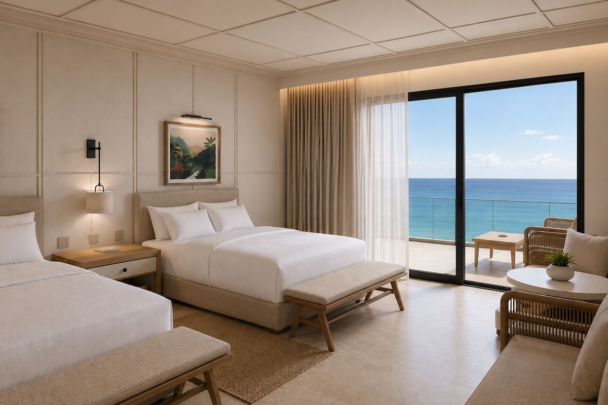 A hotel room with two beds, a balcony with a view of the ocean, and a seating area with a table and chairs.