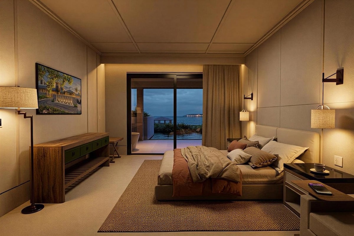 A modern hotel room with a bed, bedside tables, a bench, and a view of the ocean.