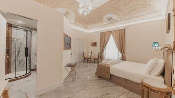 A hotel room with a bed, a shower, a chair, and a table.