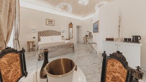 Una habitación con una cama, una araña, un armario y un espejo.