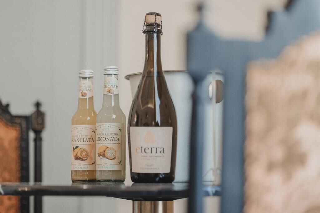 Three bottles of wine on a shelf, with one larger bottle labeled 'eterra.'