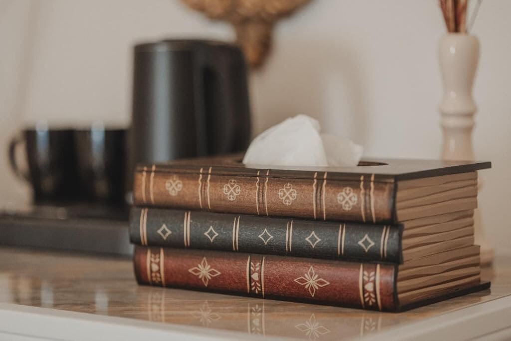 Une pile de livres aux motifs décoratifs, posée sur une surface.