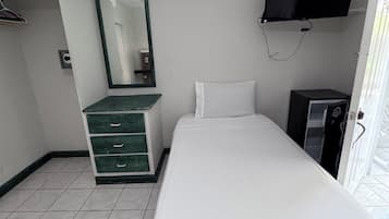 Ein Hotelzimmer mit Bett, Schminktisch, Fernseher und Kleiderschrank.
