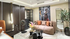 A modern living room with a sofa, a coffee table, a floor lamp, and a painting on the wall. - Classic 1 bedroom apartment  (Lekki)