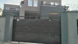 A modern two-story building with a gated entrance. - Classic 1 bedroom apartment  (Lekki)