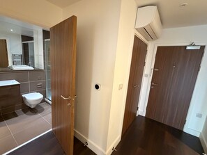 A modern bathroom with a toilet, a shower, and a sink. - London Bliss Apartment - Cozy Stay With City Views (London)