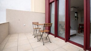 Un pequeño patio al aire libre con puerta corrediza de vidrio que da a un dormitorio.