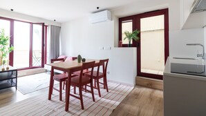 Una cocina moderna con comedor, puerta corrediza de vidrio y un balcón pequeño.