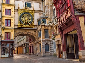 A historic street with ornate buildings, a prominent clock, and a cobblestone street. - Bienvenue à L’Olive, votre écrin vert nature au cœur de Rouen. (Rouen)