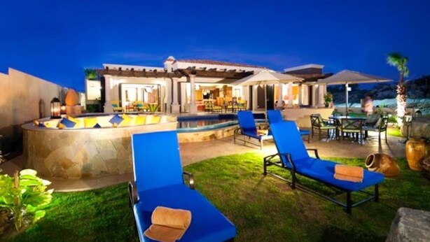 A pool area with lounge chairs, a stone structure, and a building with a patio. - Oceanview Villa - The Residence at Hacienda Encantada (Cabo San Lucas)