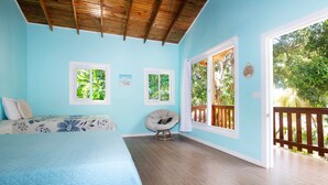 Une chambre à coucher avec un lit, une chaise et une vue sur l’extérieur.