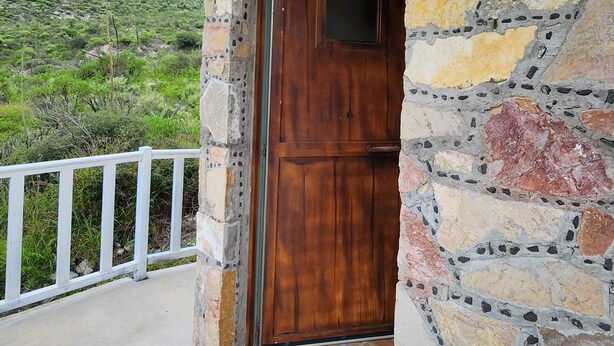 A stone building with a wooden door and a tiled entrance.