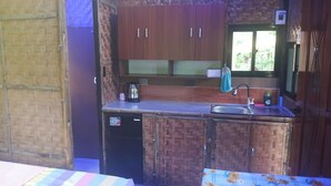A compact kitchen with wooden cabinets, a sink, and a window.
