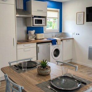 Une cuisine compacte équipée d’un four à micro-ondes, d’un grille-pain et d’un lave-linge.