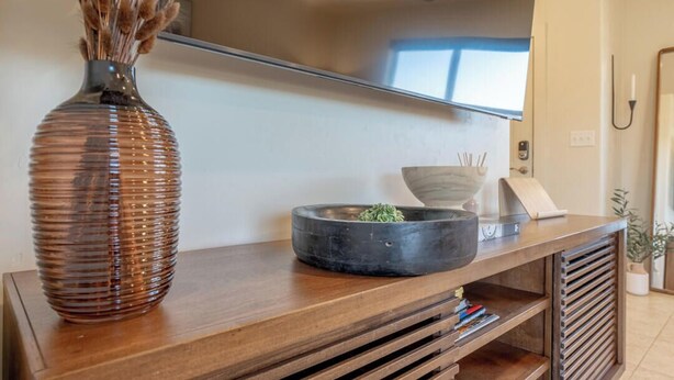 A wooden console table with a vase and a bowl. - Sandstone Sanctuary | Moab Townhome w/ Pool & Hot Tub (Moab)