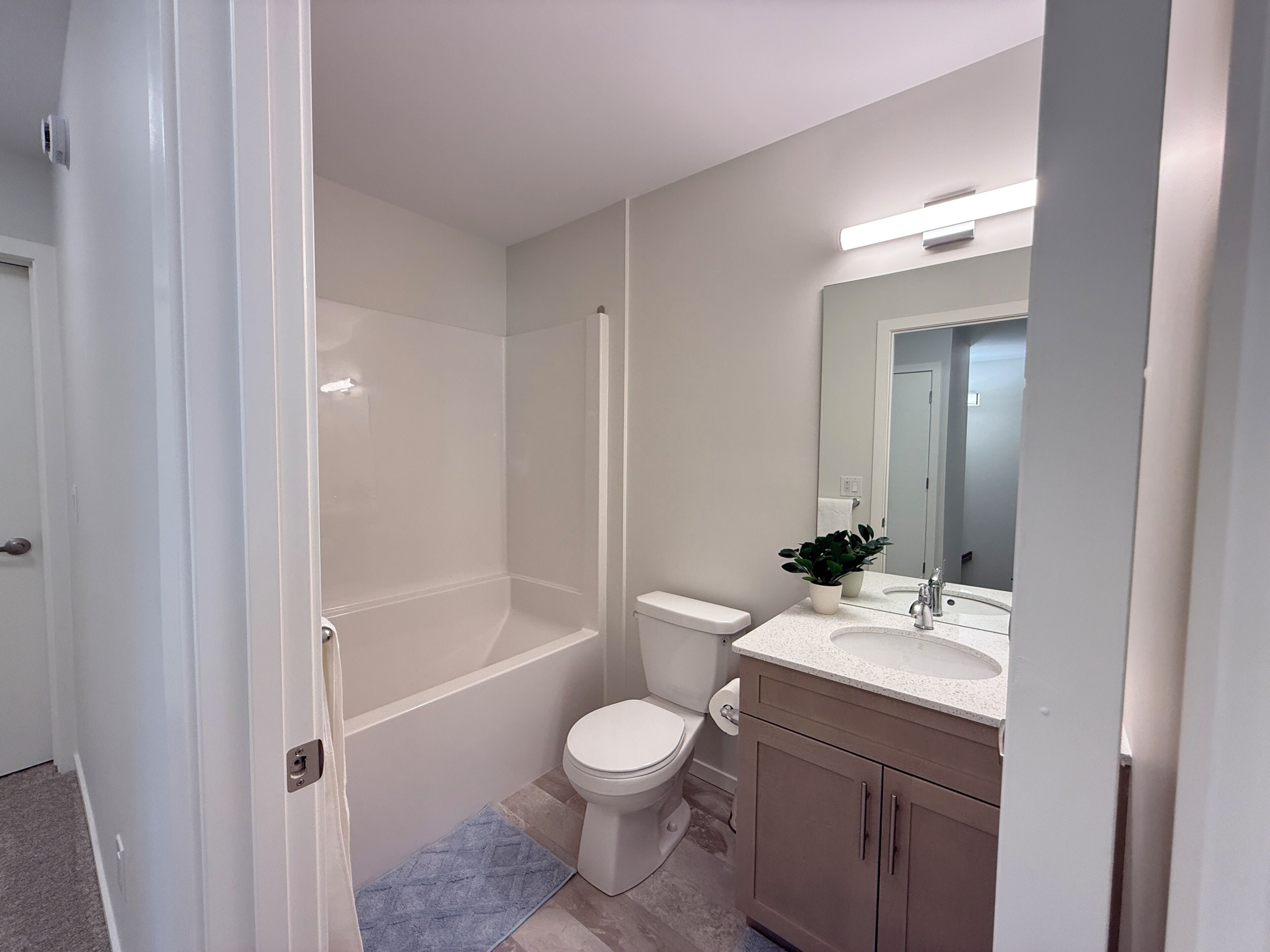 Un baño con ducha, inodoro, lavamanos y mueble.