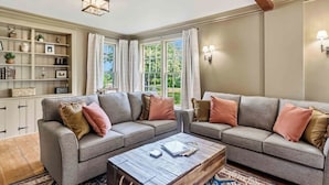 A living room with a grey sectional sofa, a wooden coffee table, and a bookshelf. - GowanBrae Grand Pre - A 250-Year-Old Estate (Grand Pré)