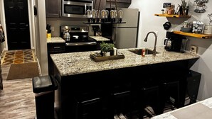 Una cocina moderna con encimeras de granito, electrodomésticos de acero inoxidable y un rincón para café.