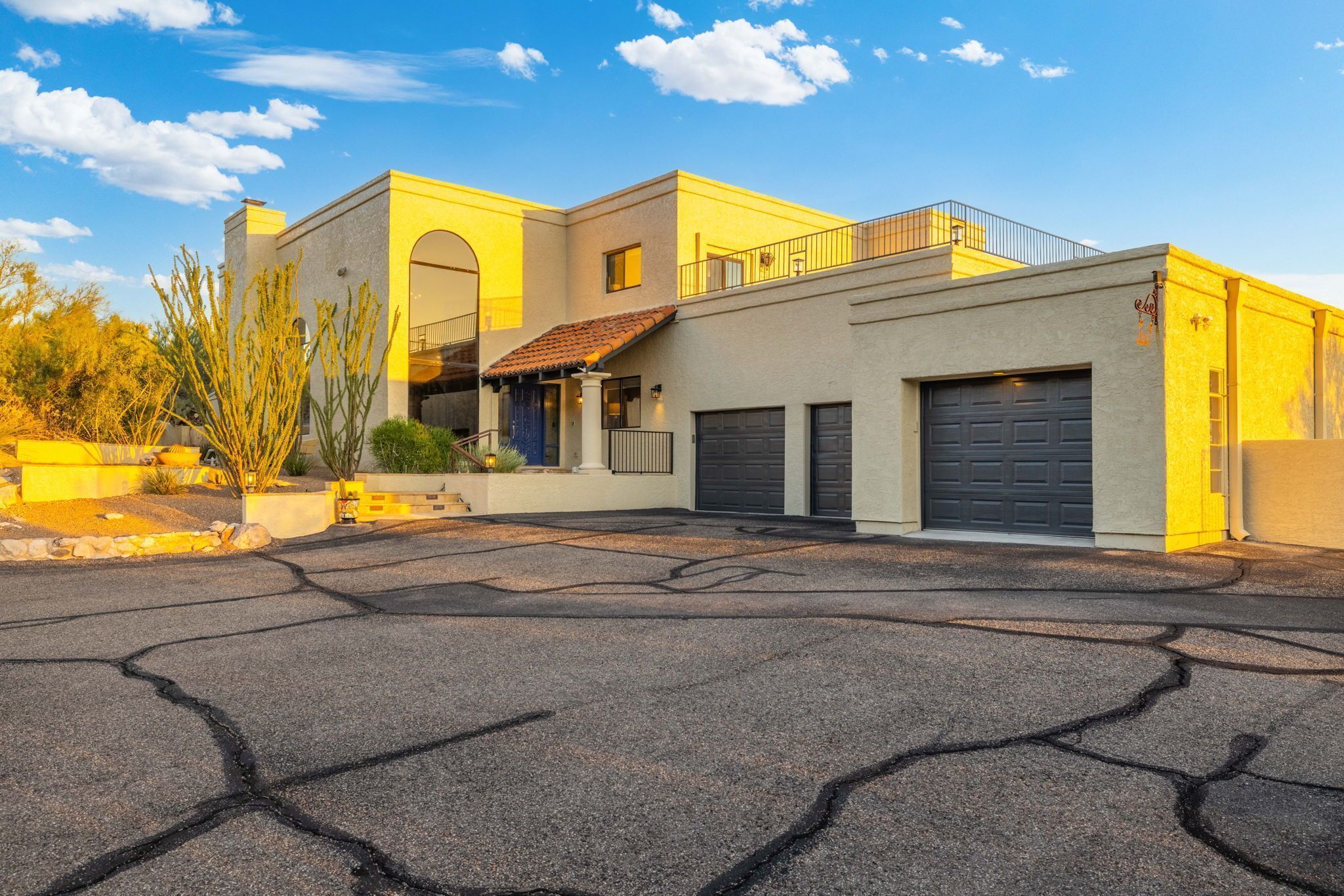 A two-story house with a garage, a balcony, and a driveway.