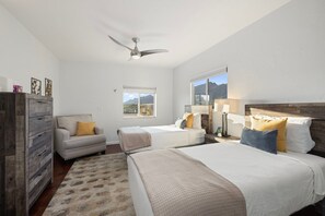 Une chambre à coucher avec un lit, un canapé, une commode et un ventilateur de plafond.