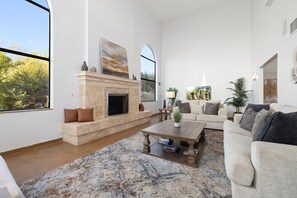 A spacious living room with a fireplace, a large window, and a comfortable seating area.
