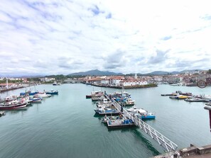 A harbor with boats docked, a pier, and buildings in the background. - SAINT-JEAN DE LUZ, CENTRE HISTORIQUE, QUAI DE L'INFANTE (ST JEAN DE LUZ)