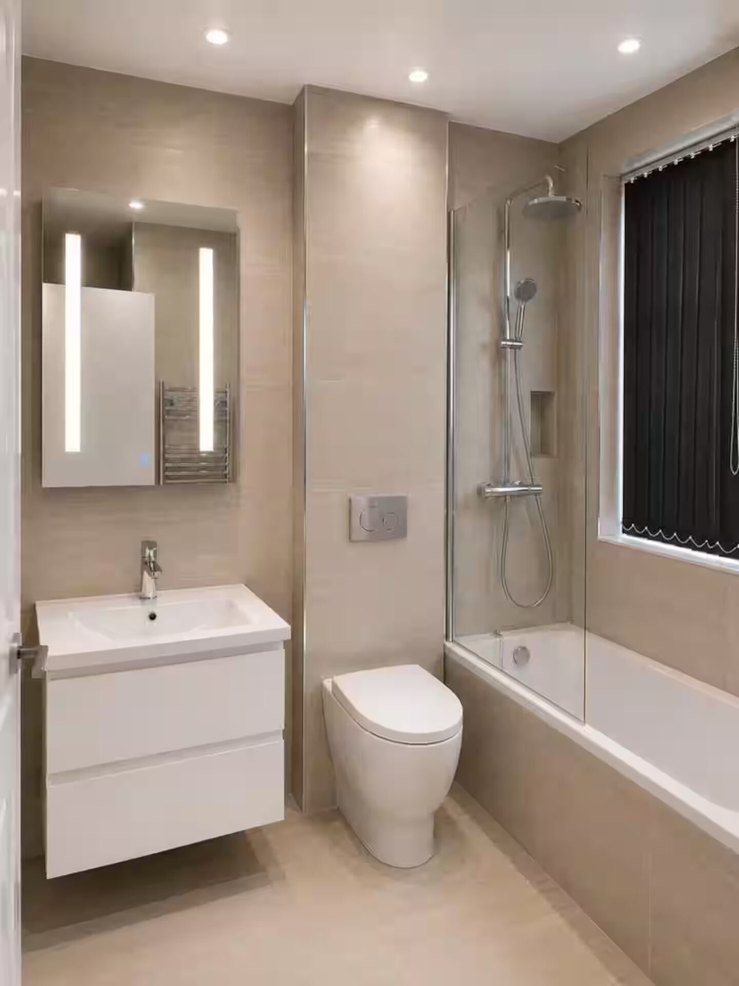 A modern bathroom with a white sink, toilet, and shower area.