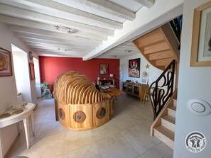 A spacious living area with a unique wooden structure, a staircase, and a red accent wall. - Alice's House - TERNAND (TERNAND)