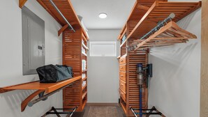 A narrow hallway with wooden lockers, a bench, and a hanging rack. - Indigo Hideaway | Romantic + Fire pit (Nappanee)