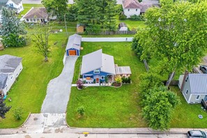 Luchtbeeld van een woonwijk met een huis, een schuin dak, voortuin en oprit naar de ingang.
