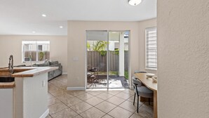 A spacious kitchen with a dining area, sliding glass doors to a backyard, and a small outdoor seating area. - La Cubanita (Miami)