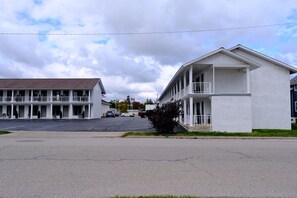 A two-story motel with a flat roof and a balcony on the second floor.