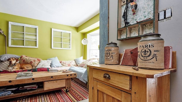 A cozy room with a bed, a wooden cabinet, and a window.