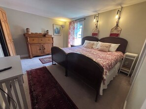 Une chambre à coucher avec un lit, une commode et un radiateur.
