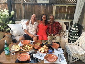 A group of people sitting on a couch with a table of food and drinks in front of them. - Room-french Nest, Private Bathroom! Chec (Burlington)