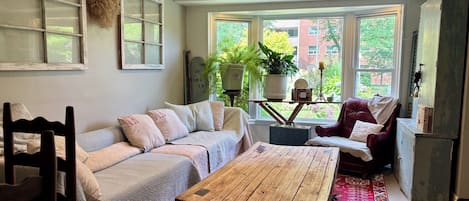A cozy living room with a sofa, a wooden coffee table, and a red patterned rug.