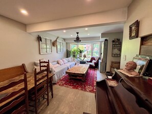 A cozy living room with a sofa, wooden chairs, a coffee table, and a piano. - Room-french Nest, Private Bathroom! Chec (Burlington)